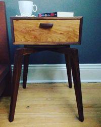 Walnut bedside table with cherry drawer front.