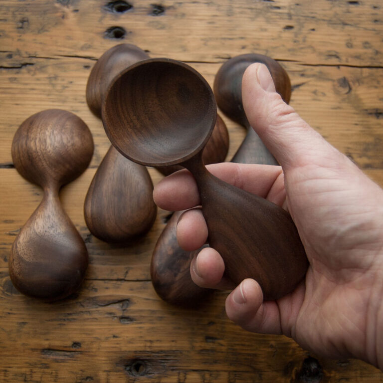 hand holding a wooden coffee scoop